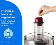 Hand is placing a red apple in the nutribullet Juicer feed chute. A blue panel on the left reads "Fits whole fruits and vegetables". An icon showing an apple and feed chute in a circle is situated beneath the text.