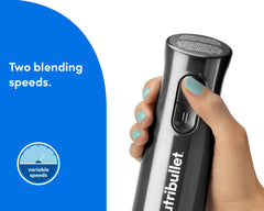 A hand holding the nutribullet Lite blender handle, showing the two-speed control buttons for variable blending power.