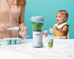 NutriBullet Baby with peas on blue background.