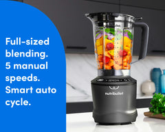 The SmartSense Blender is shown filled with colorful fruits and vegetables on a marble countertop. A blue panel to the left of the image reads "full-sized blending. 5 manual speeds. Smart auto cycle."