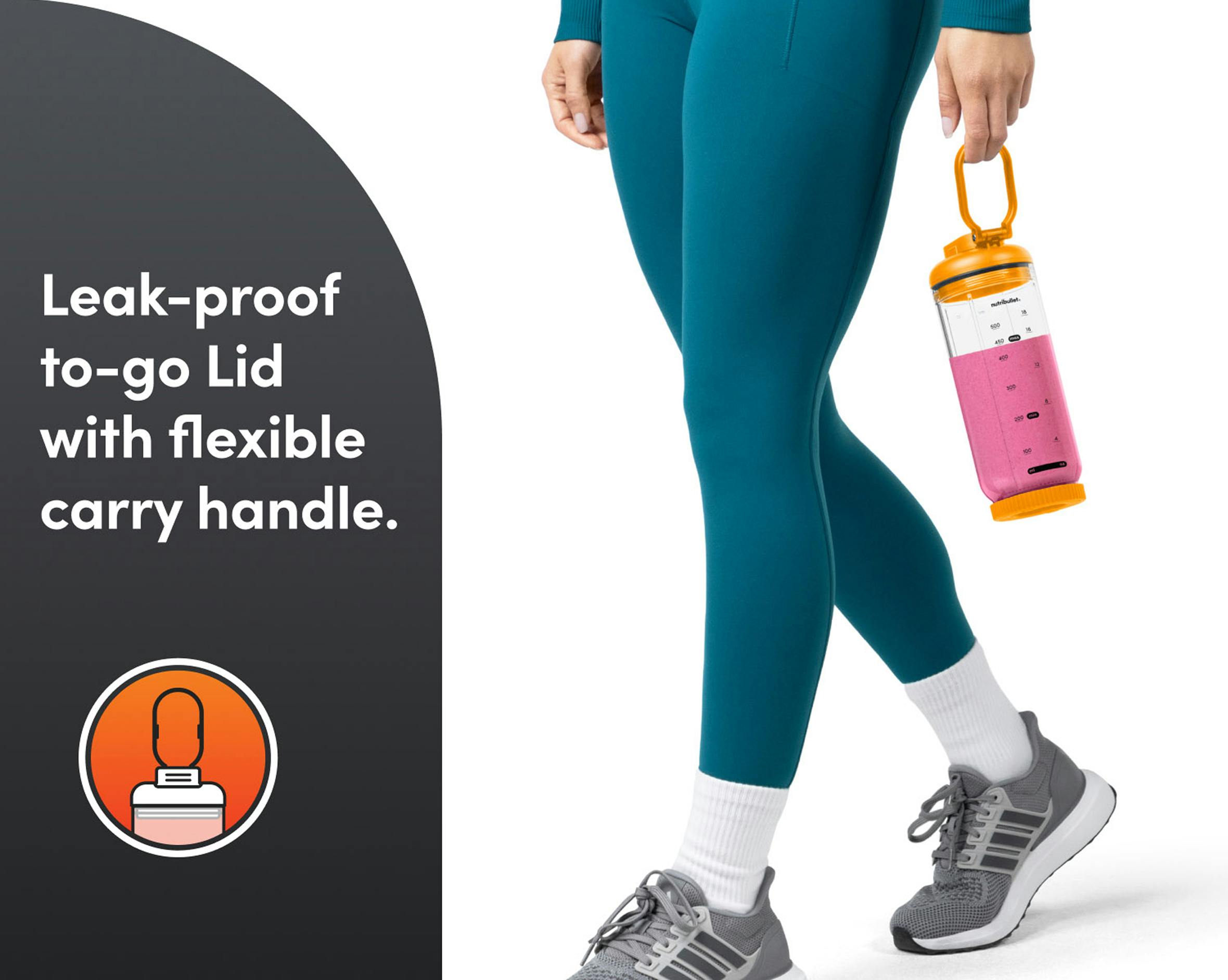 A person walking outdoors holding the blender by its flexible carry handle to show portability.