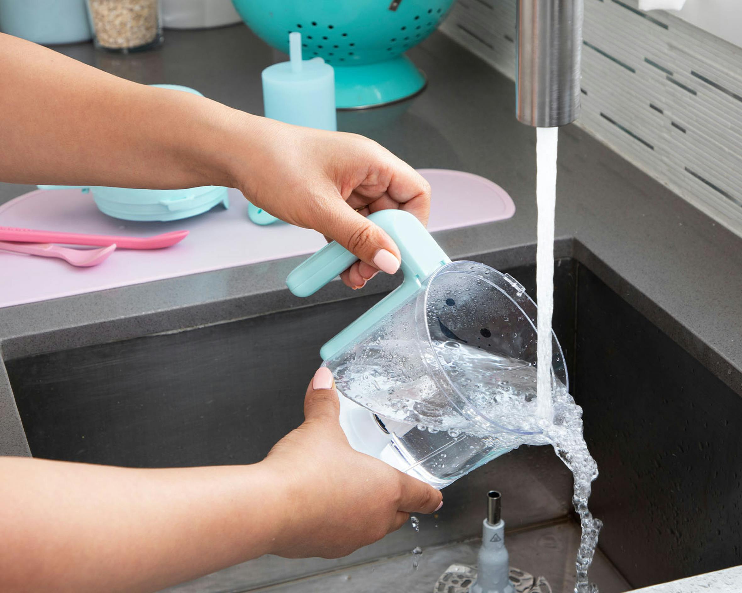 Person washing the baby steam and blend bowl in a sink