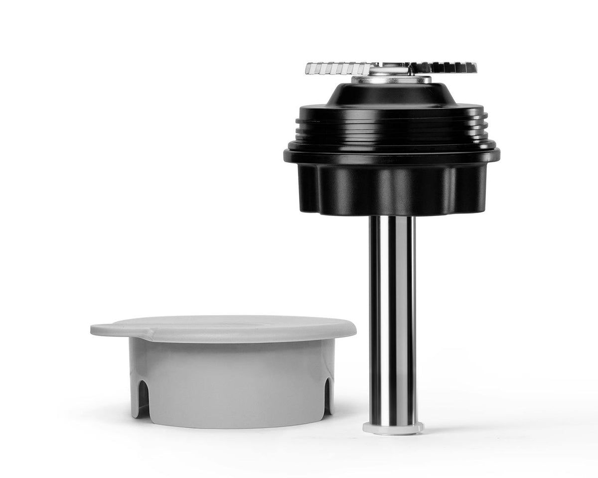A black blending blade base with a long metal shaft next to a circular grey plastic cap component.