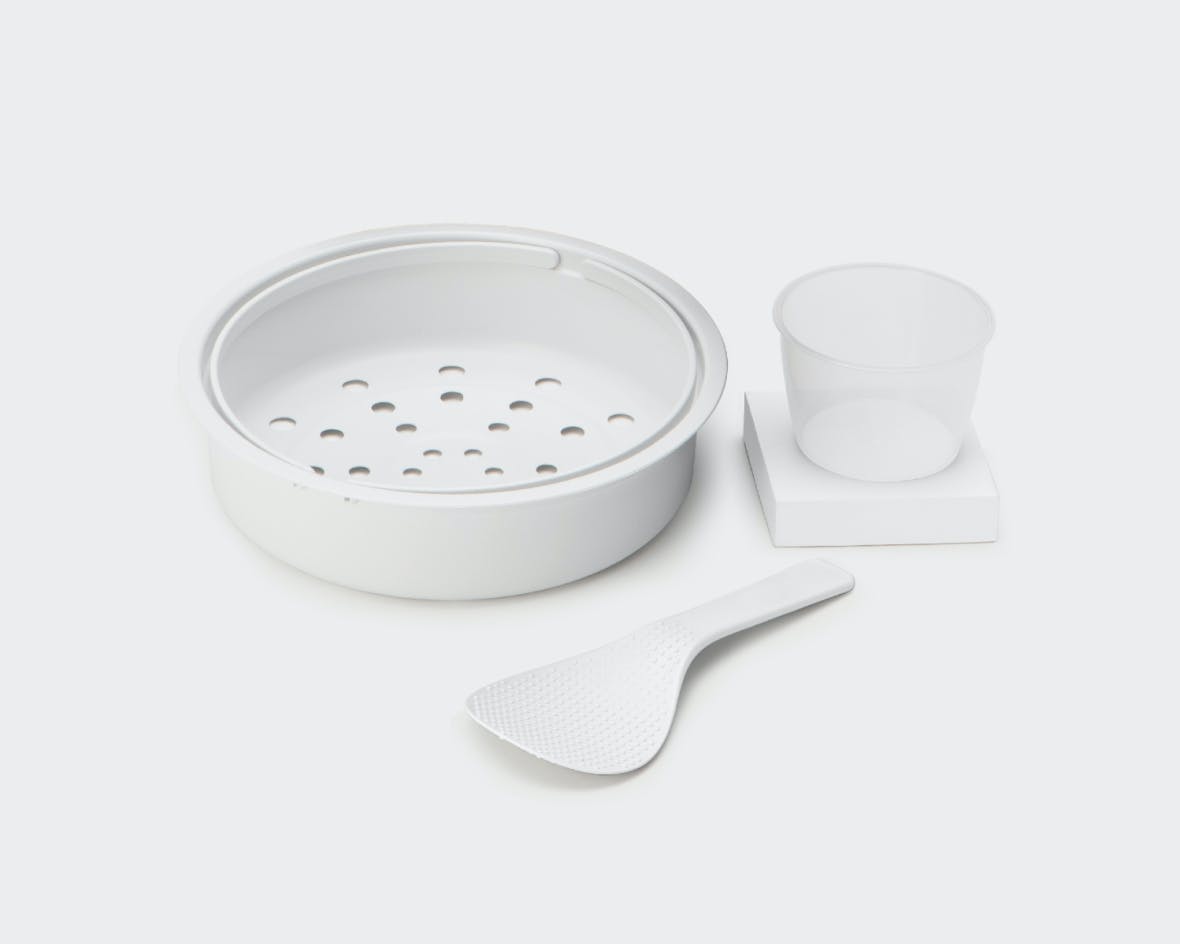 Kitchen utensil set including a steamer with holes, a spoon and a measuring cup