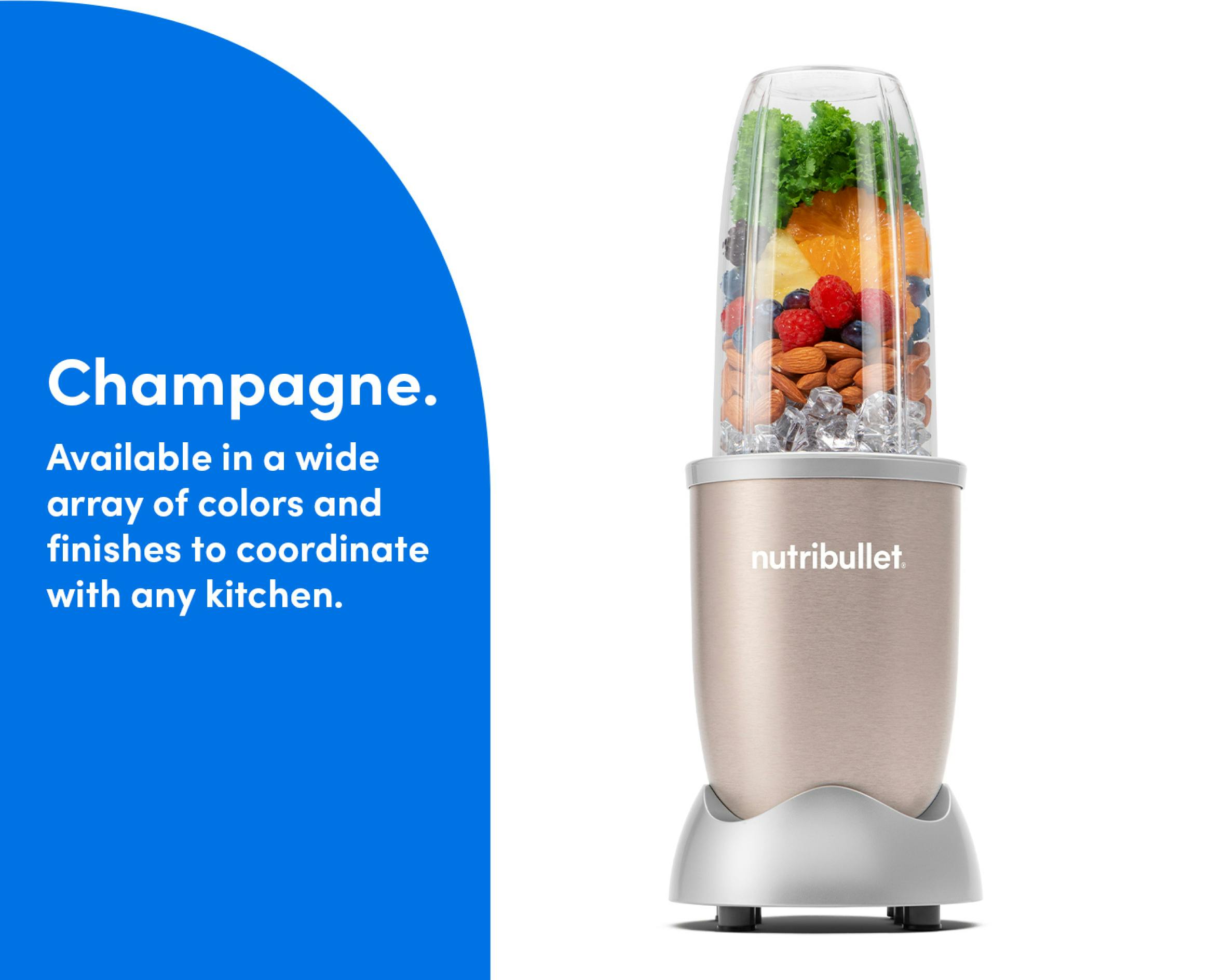 The Champagne nutribullet Pro rests on a kitchen counter. The Tall Cup is attached to the Power Base and filled with fruit, ice, and nuts.