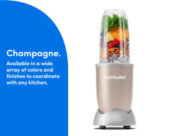 The Champagne nutribullet Pro rests on a kitchen counter. The Tall Cup is attached to the Power Base and filled with fruit, ice, and nuts.