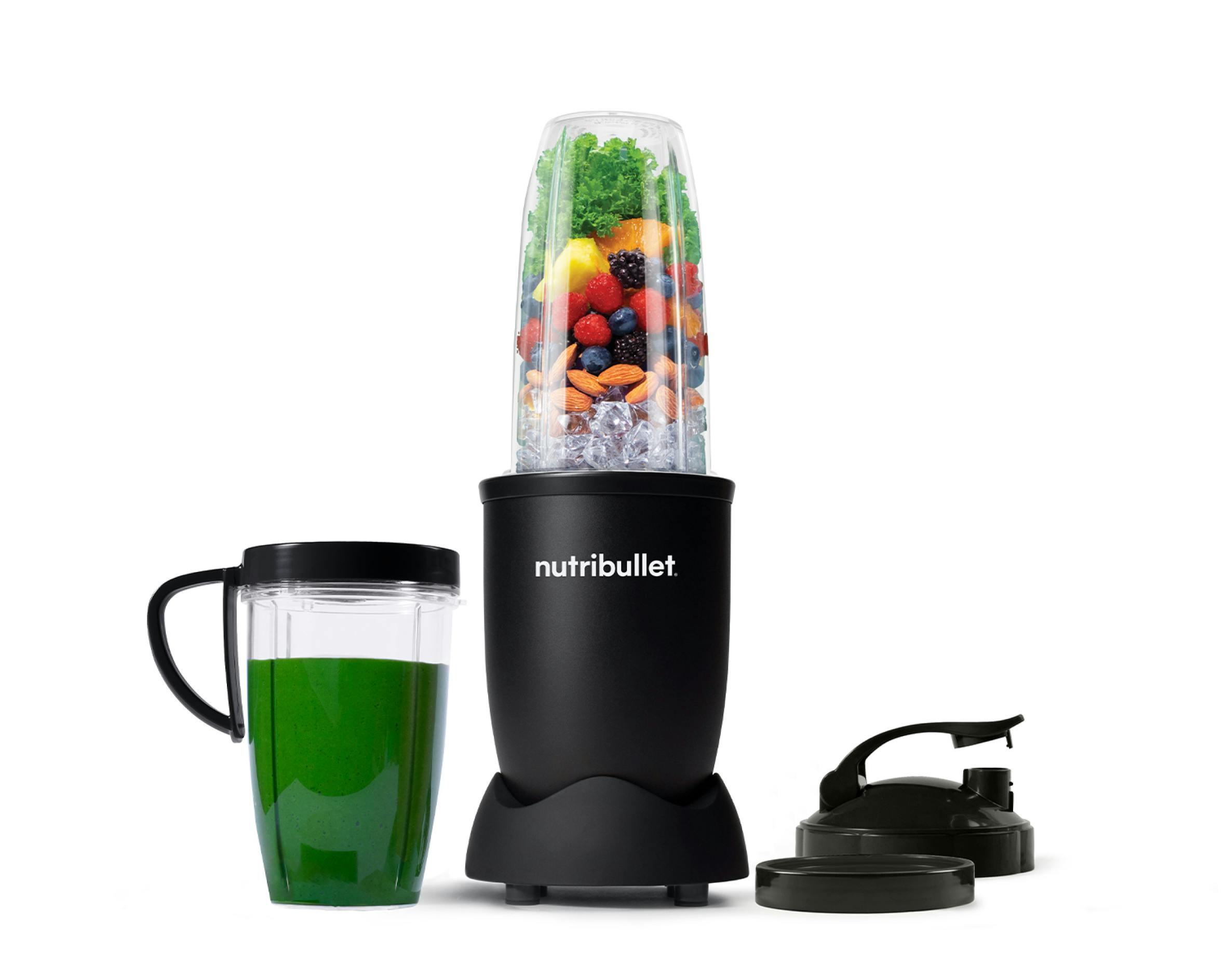 The full configuration of the nutribullet Pro rests on a white background. This includes the Power Base, Tall Cup, an extra Tall Cup with the Comfort Lip ring attached filled with a green smoothie, one extra Comfort Lip Ring, and two To-Go Lids.