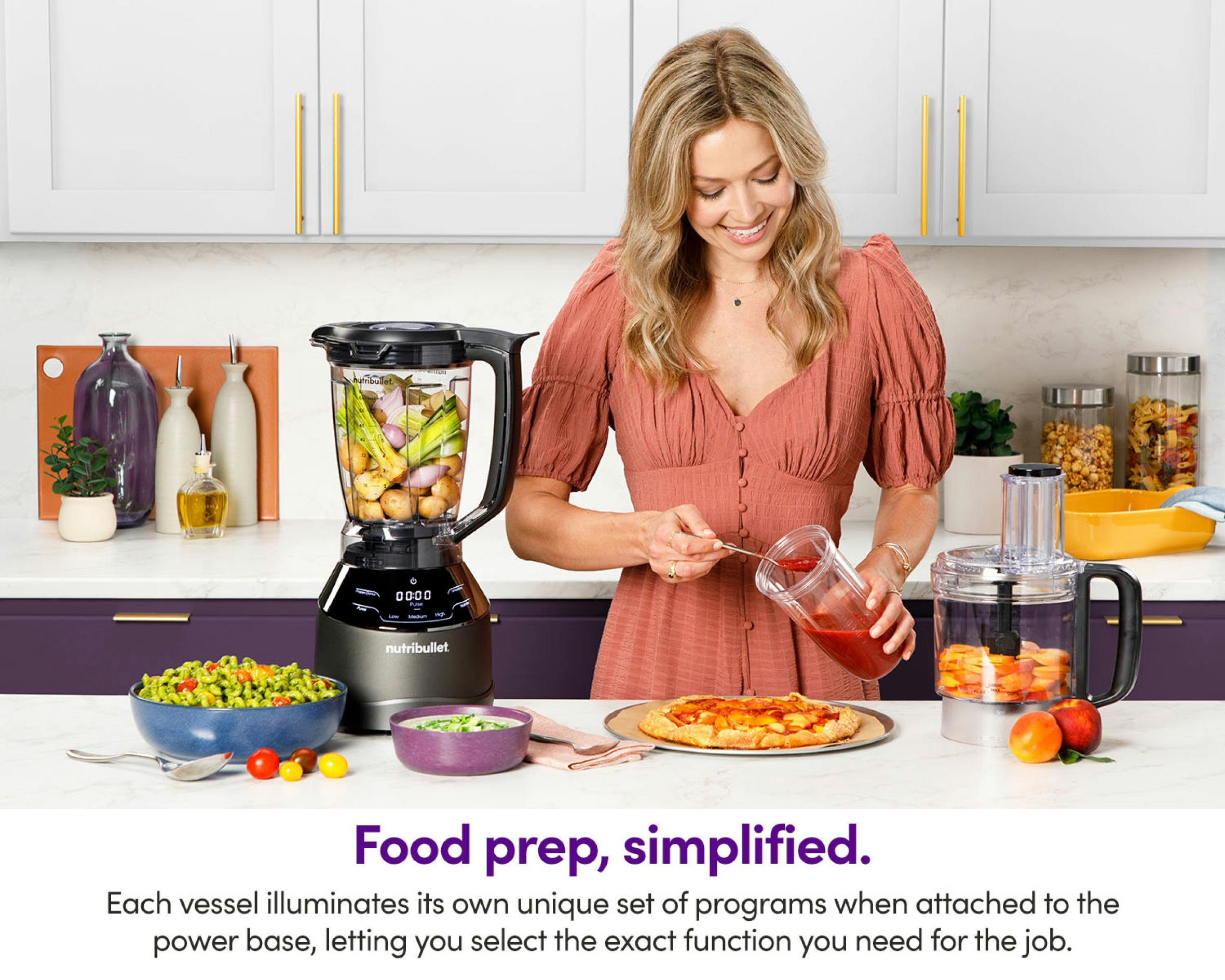 Woman standing next to nutribullet Triple Prep, while holding a blending cup on kitchen's countertop