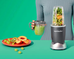 NutriBullet original with cup on green background.