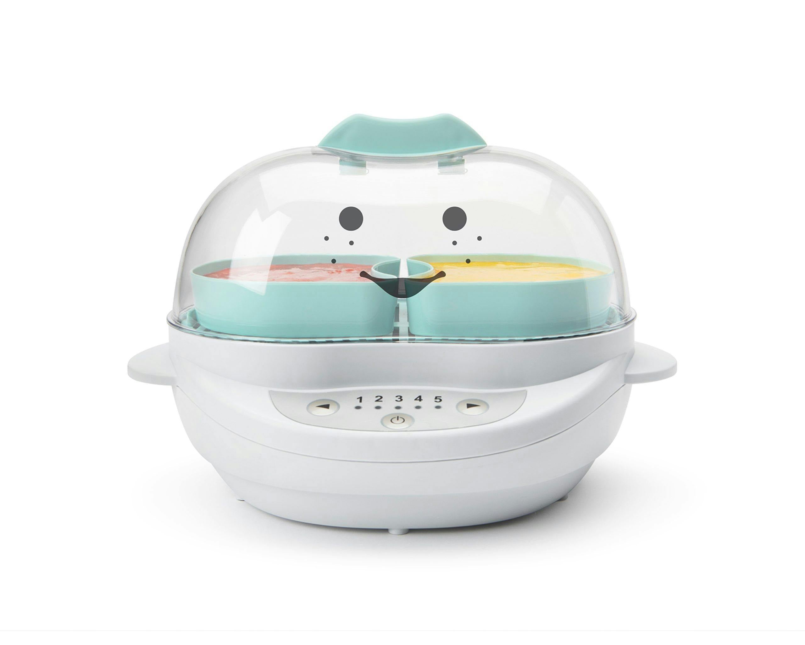 White NutriBullet Baby Steamer with teal containers inside filled with yellow and pink puree with smiley face.