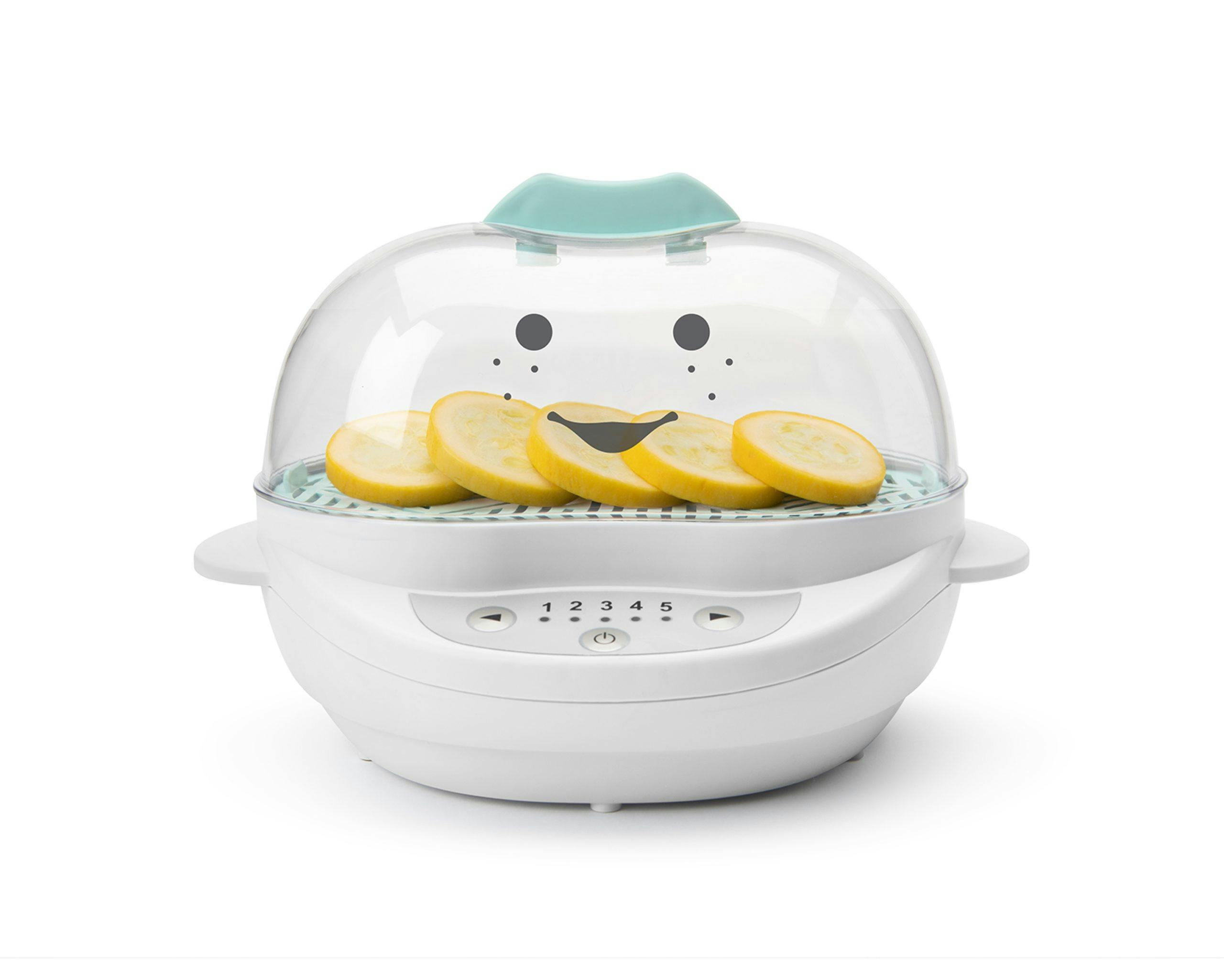 White NutriBullet Baby Steamer filled with sliced veggies with teal accents with smiley face.